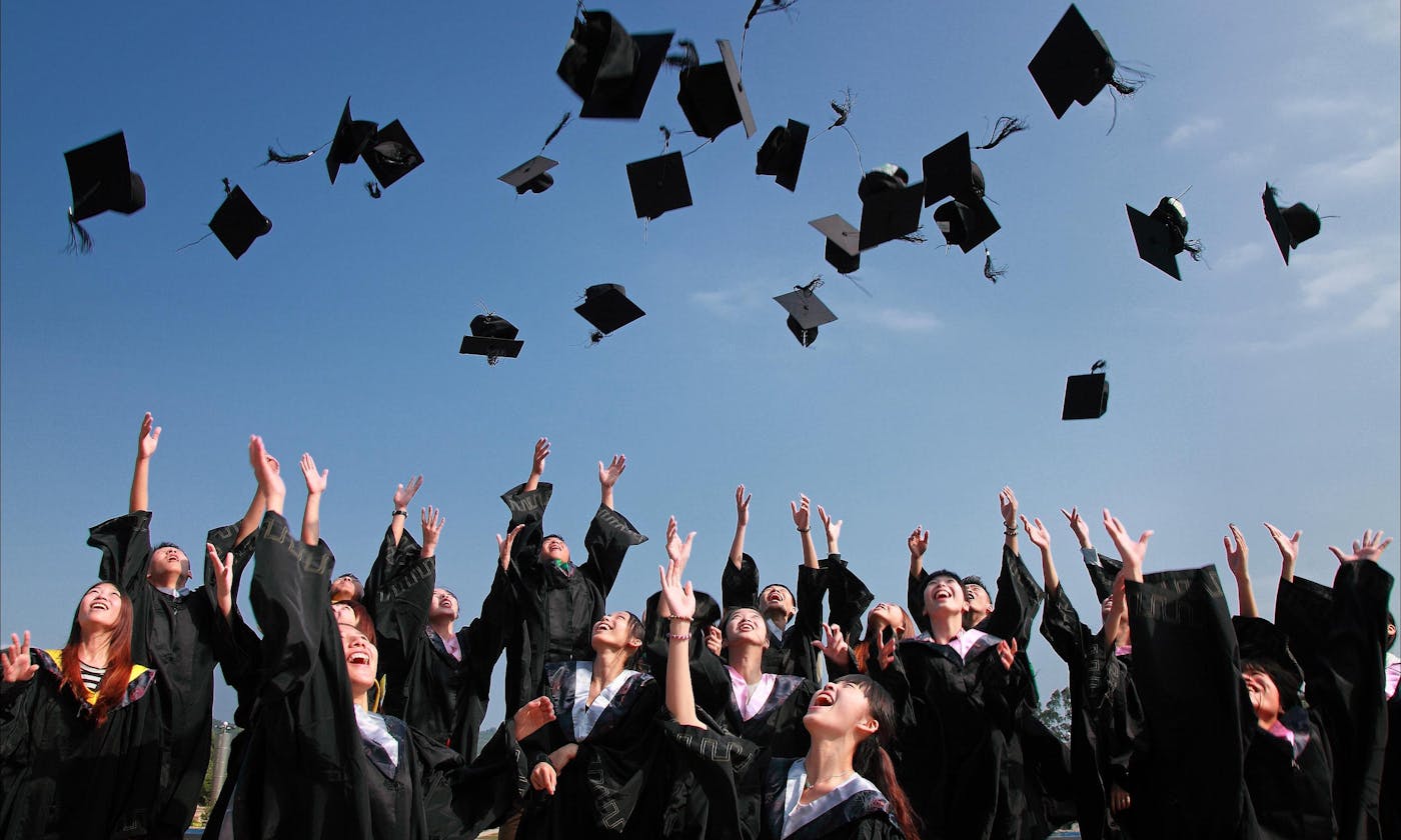 Graduates tossing caps in celebration